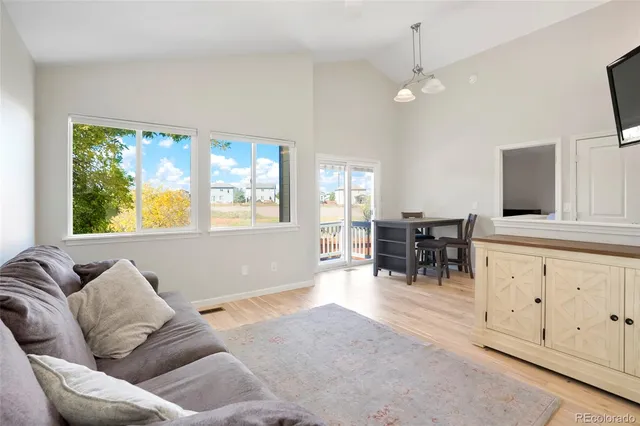 a living room with furniture a dining table and a refrigerator