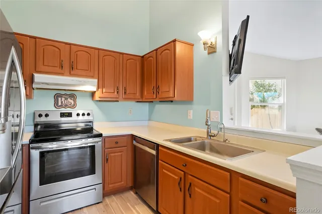 a kitchen with stainless steel appliances granite countertop a refrigerator and a stove top oven