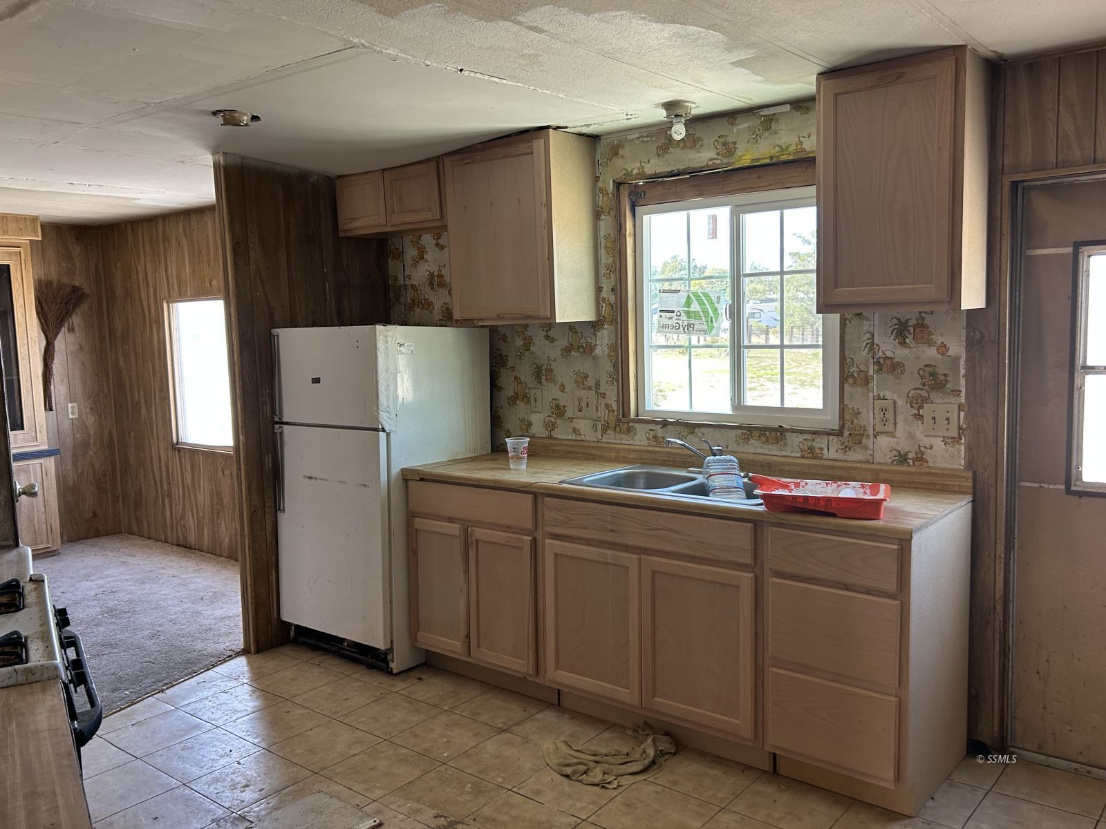 1057 North Calvert Boulevard Ridgecrest, CA 93555 - Photo 9 of 23 a kitchen that has a sink and a refrigerator in it