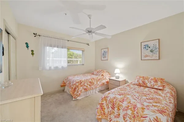 a bedroom with two beds and a chandelier