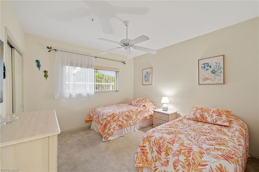 14771 Hole In 1 Circle, Unit 108 Fort Myers, FL 33919 - Photo 11 of 22 a bedroom with two beds and a chandelier