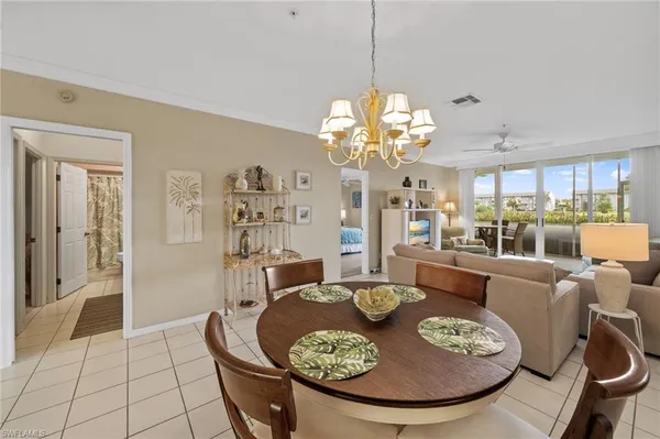 a dining room with furniture a kitchen and chandelier