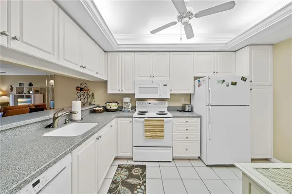 a kitchen with cabinets appliances a sink and a counter top space