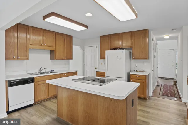 a kitchen with a sink a refrigerator and cabinets