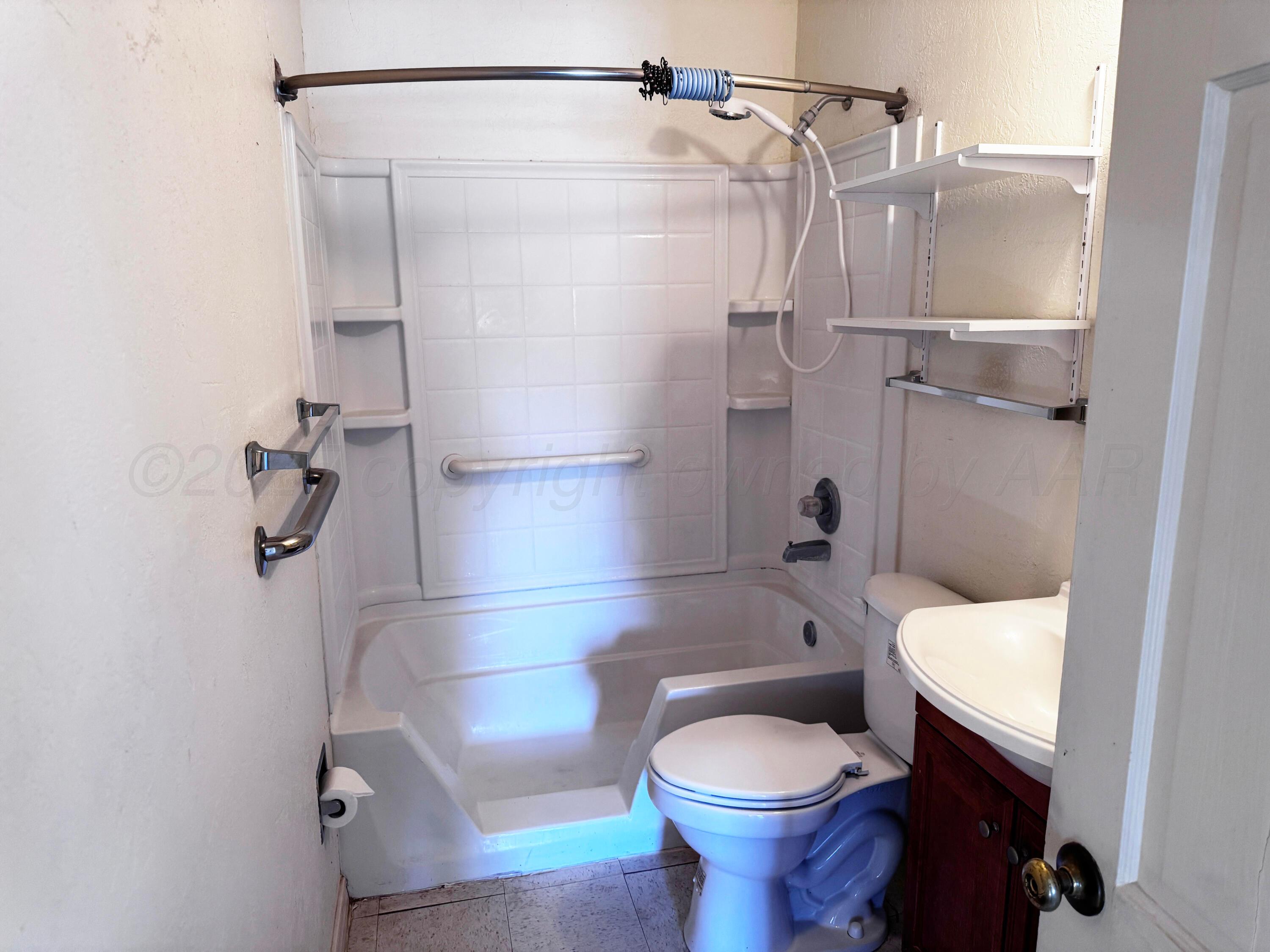 4004 South Hayden Street Amarillo, TX 79110 - Photo 11 of 14 a bathroom with a toilet and a shower