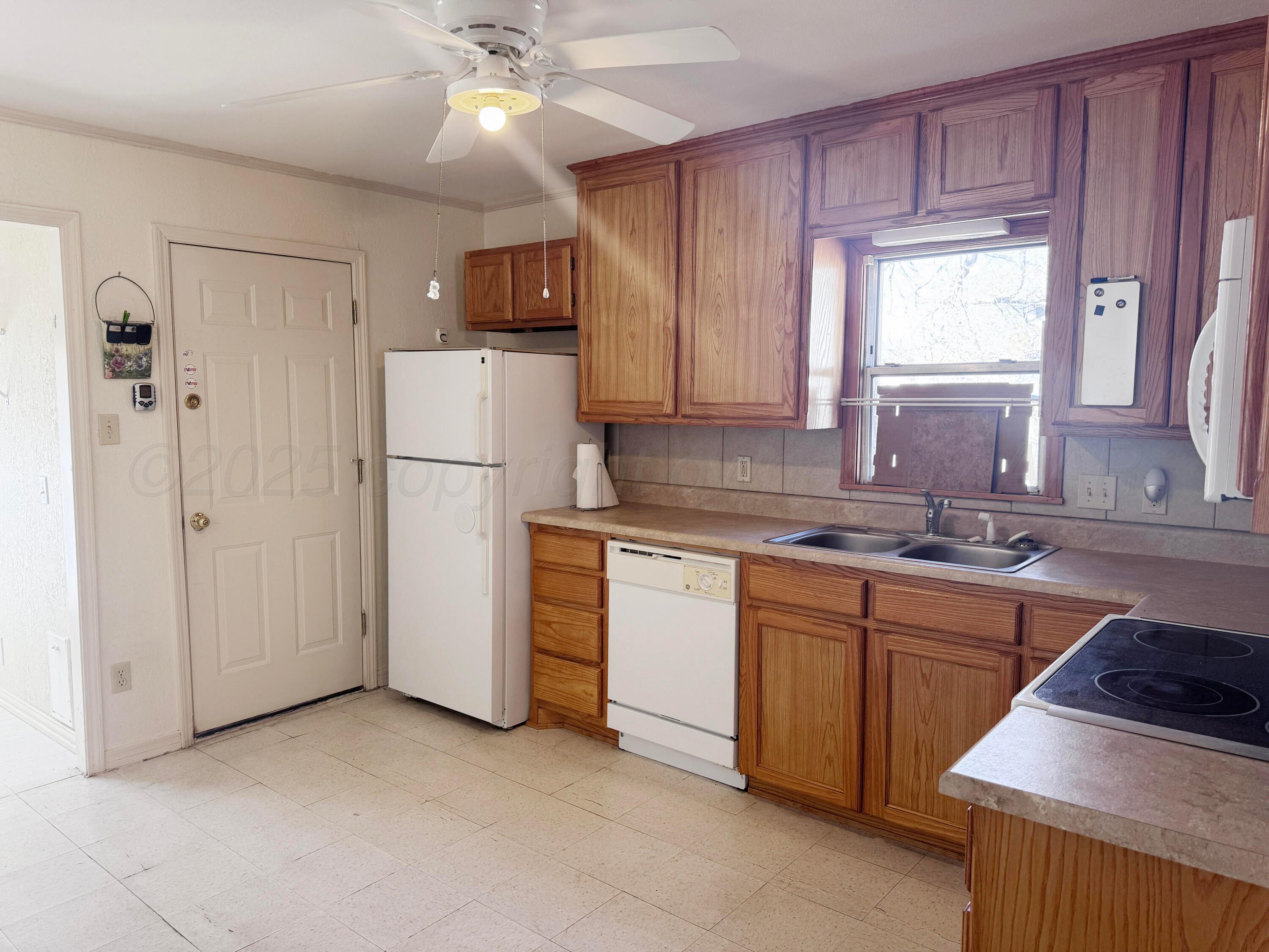 4004 South Hayden Street Amarillo, TX 79110 - Photo 5 of 14 a kitchen with a refrigerator sink and cabinets