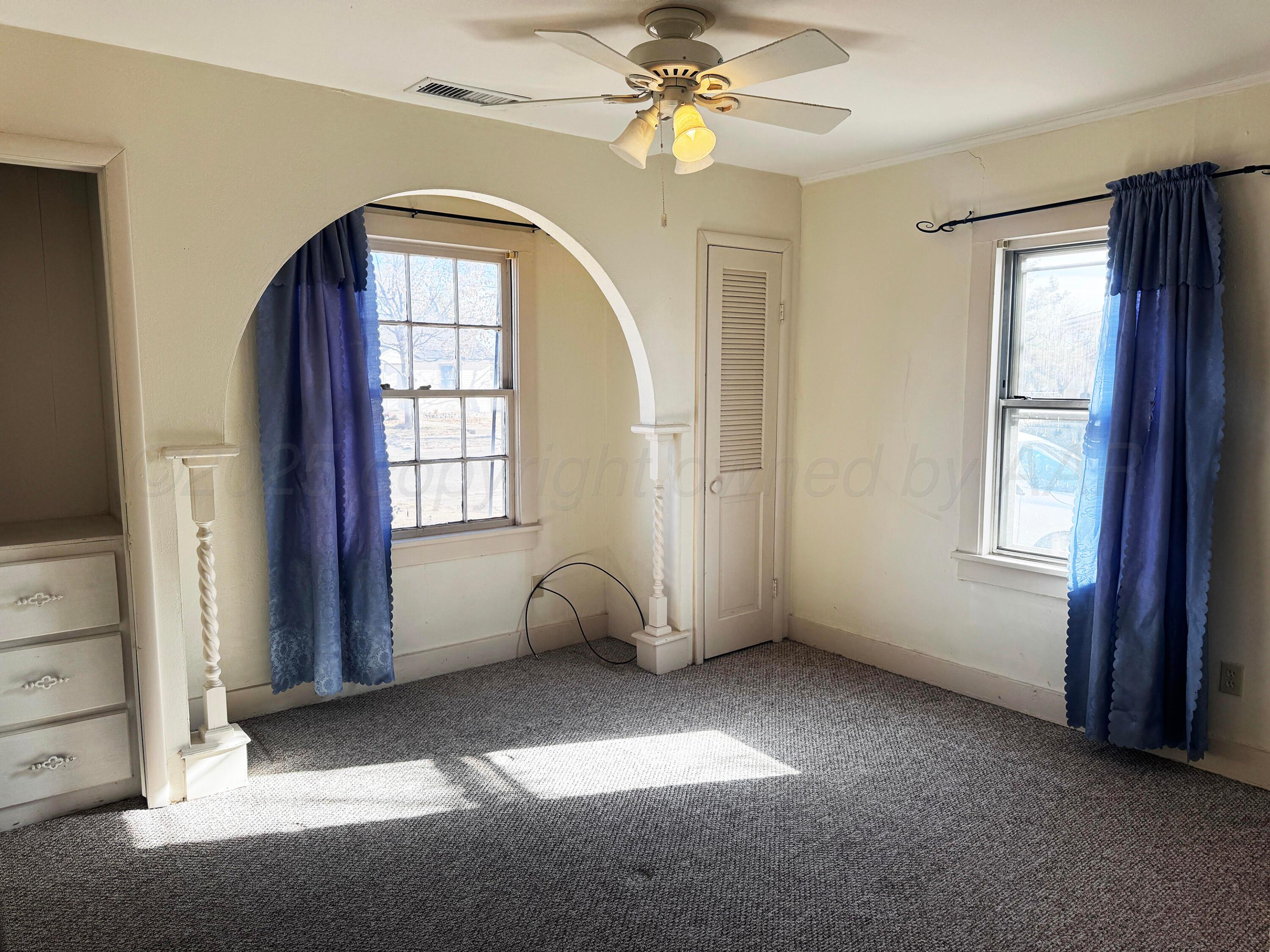 4004 South Hayden Street Amarillo, TX 79110 - Photo 8 of 14 an empty room with windows and chandelier fan