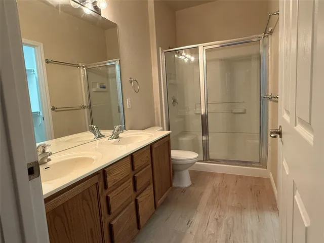 a bathroom with a sink a toilet a mirror and shower