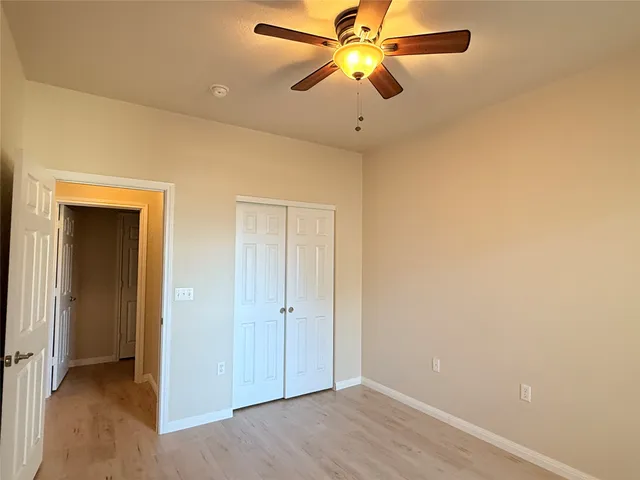 an empty room with a ceiling fan and a window