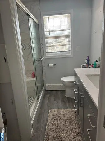 a bathroom with a sink a toilet window and a shower