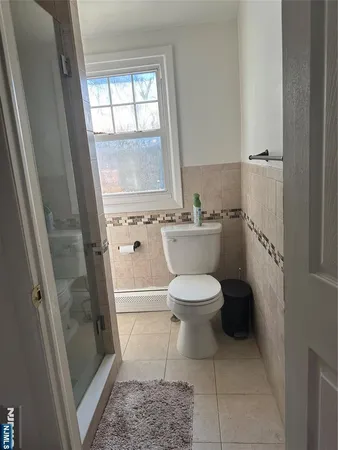 a white toilet sitting next to a window in a bathroom