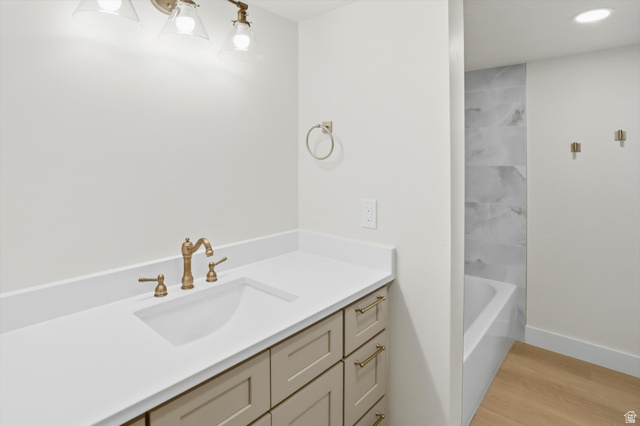 8760 Rustler Road Cottonwood Heights, UT 84093 - Photo 39 of 57 Bathroom vanity featuring a single integrated sink with a bronze-finish faucet, a light-toned countertop, and cabinetry with bronze-finish hardware