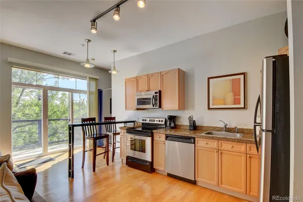a kitchen with stainless steel appliances granite countertop a stove and a refrigerator