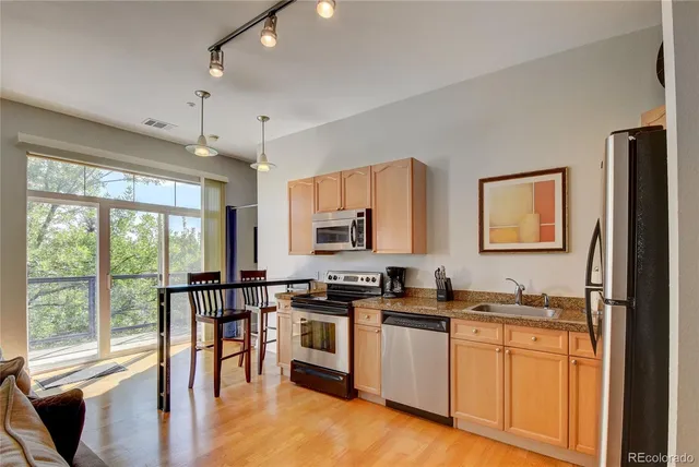 a kitchen with stainless steel appliances granite countertop a stove and a refrigerator