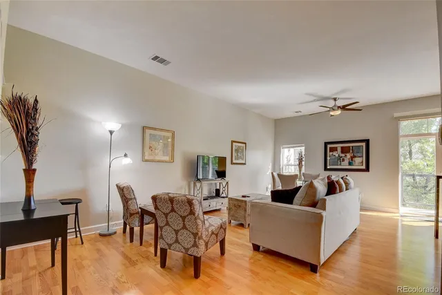 a living room with furniture a desk and chair with wooden floor