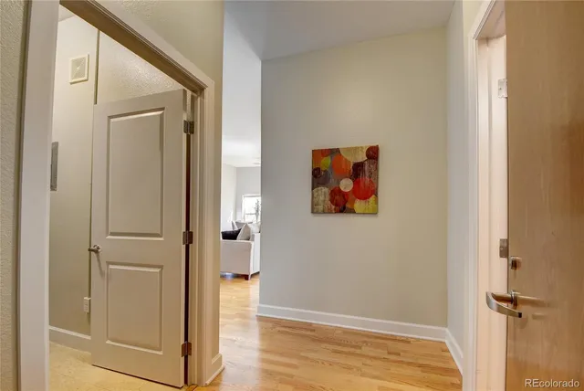 a view of a hallway with wooden floor and closet