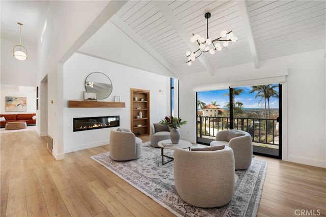 a living room with furniture a fireplace and a chandelier