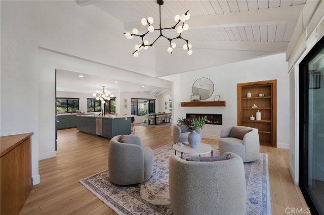 a living room with fireplace furniture and a chandelier
