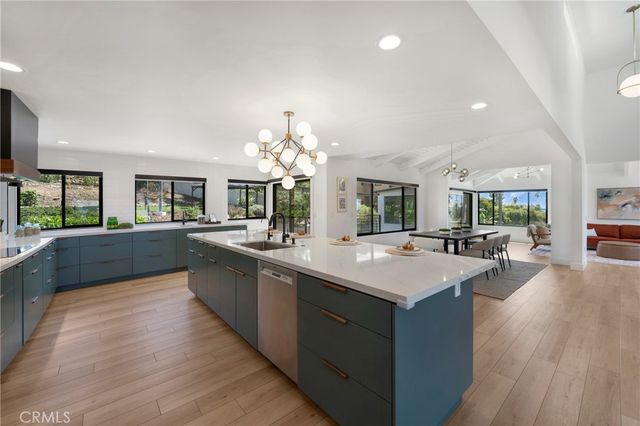 a large kitchen with sink a counter top space and living room view