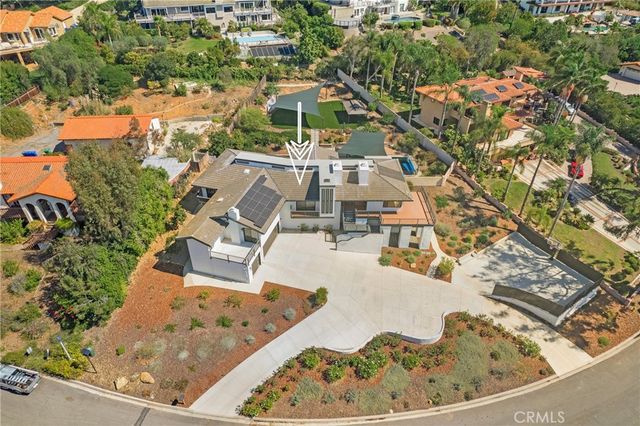 an aerial view of a house with swimming pool and large trees