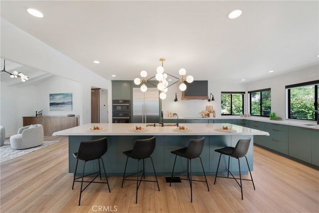 a dining room with wooden floor and large windows