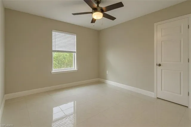 an empty room with a window and a fan