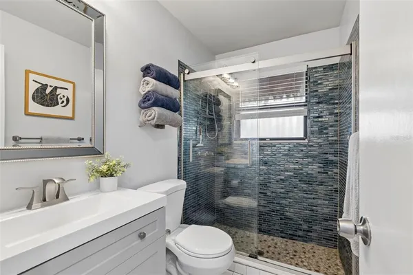 a bathroom with a shower toilet and sink