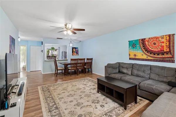 a living room with furniture and a flat screen tv with kitchen view
