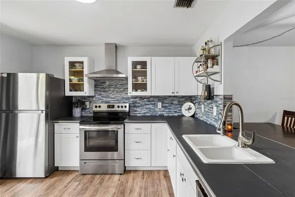 a kitchen with stainless steel appliances granite countertop a sink stove and refrigerator