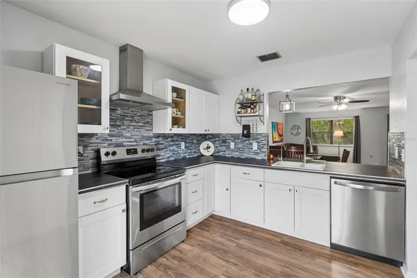 a kitchen with white cabinets and appliances