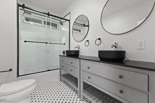 a bathroom with a sink a toilet and a mirror