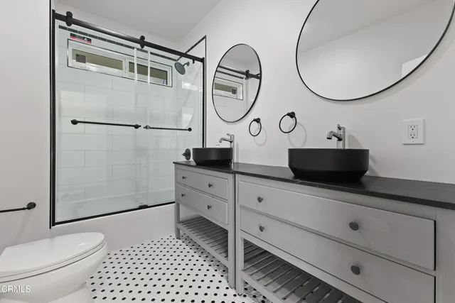 a bathroom with a sink a toilet and a mirror