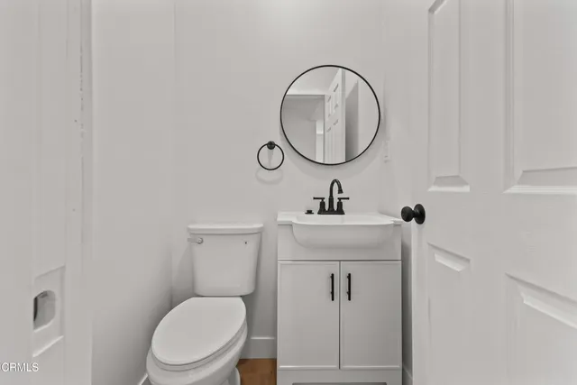 a bathroom with a toilet a sink and a mirror