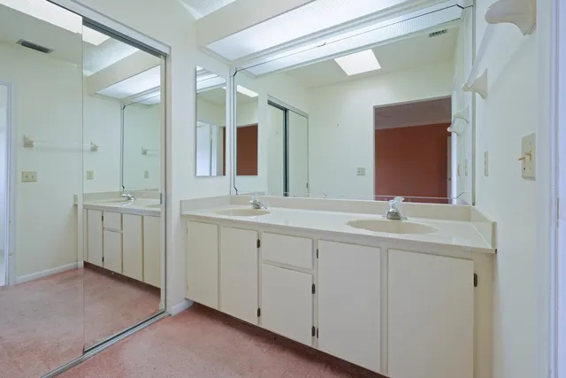 a bathroom with double sink and a mirror