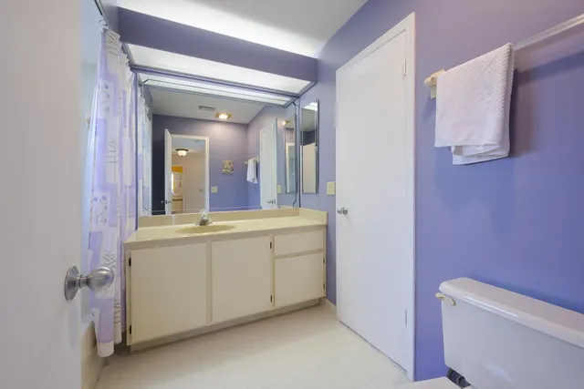 a spacious bathroom with a granite countertop sink and a mirror