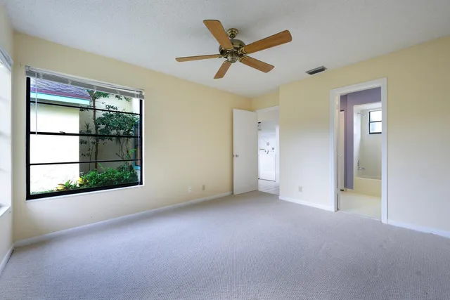 an empty room that has a window and kitchen view