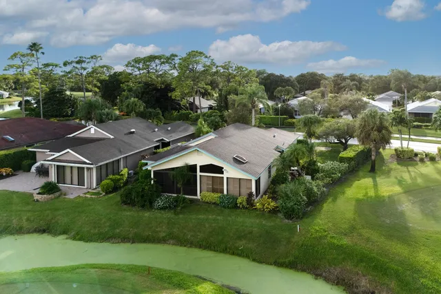 an aerial view of residential houses with outdoor space and trees