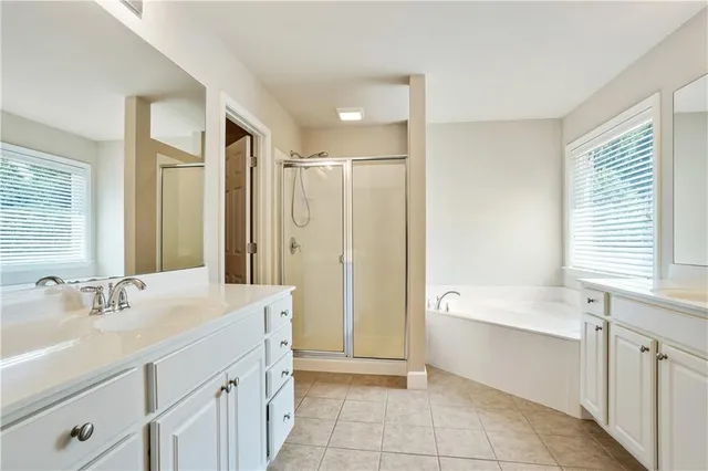 a bathroom with a tub sink shower and a mirror