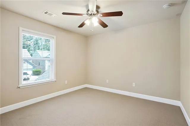 an empty room with a window and a fan