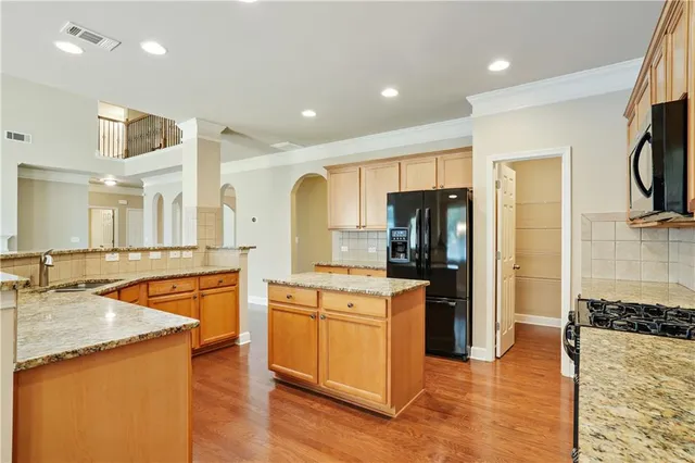 a kitchen with stainless steel appliances granite countertop a refrigerator and a sink