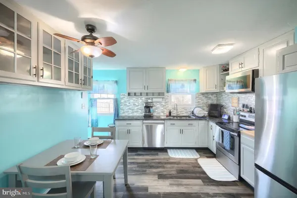 a kitchen with stainless steel appliances granite countertop a stove refrigerator a sink dishwasher and microwave oven
