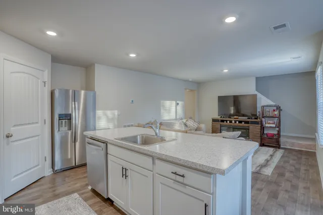 a kitchen with stainless steel appliances granite countertop a sink a stove a refrigerator a microwave and cabinets