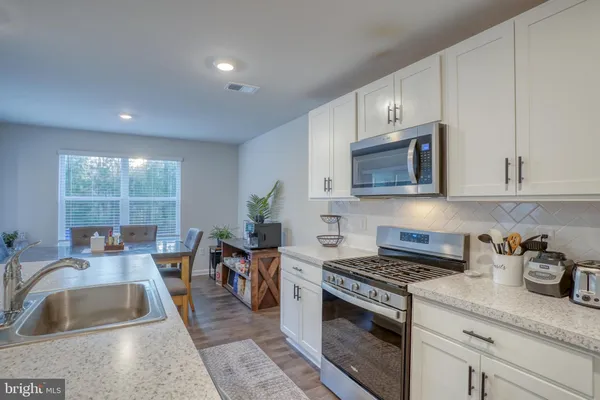 a kitchen with stainless steel appliances granite countertop a refrigerator stove and sink