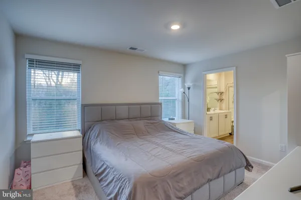 a bedroom with a bed and a flat screen tv in white cabinet