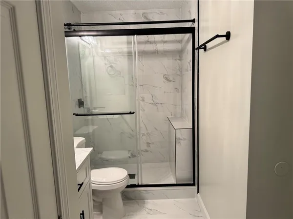 a bathroom with a toilet and a shower