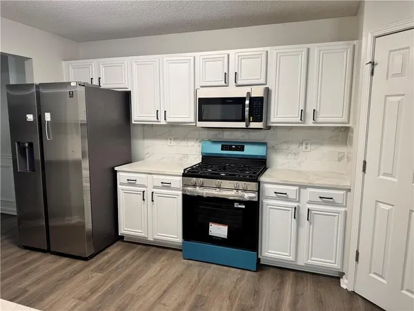 a kitchen with white cabinets and stainless steel appliances