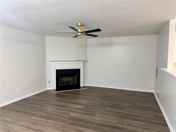 a view of empty room with wooden floor and a fireplace