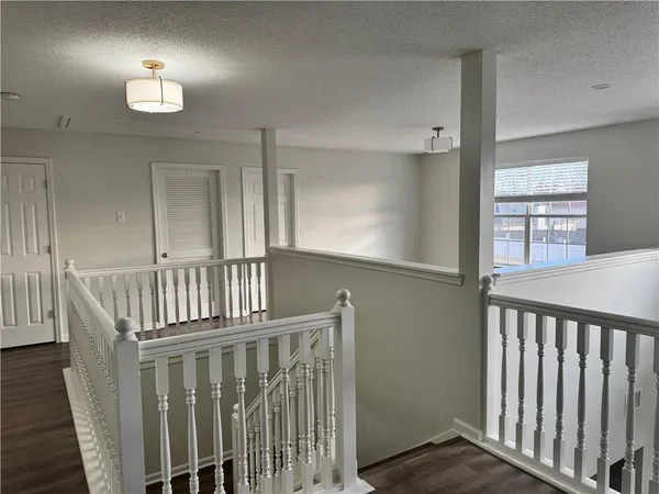 a view of staircase with railing and a window