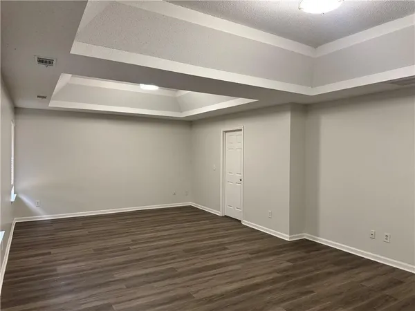 a view of an empty room with wooden floor
