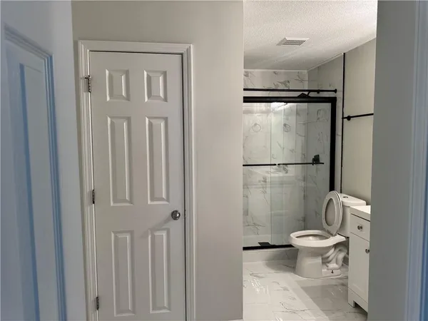a bathroom with a toilet and a shower